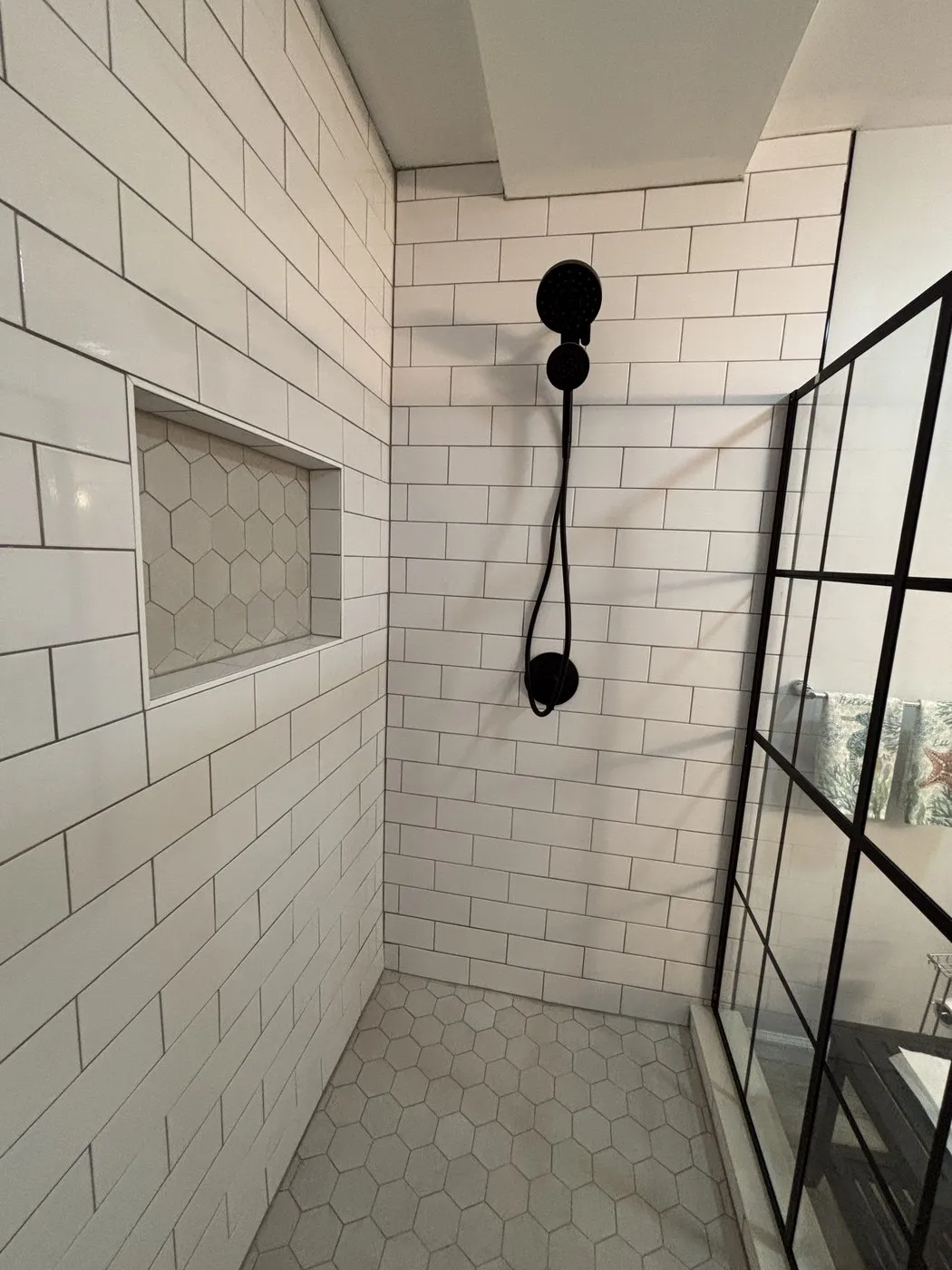 Wildwood NJ bathroom shower interior with black fixtures and built-in niche